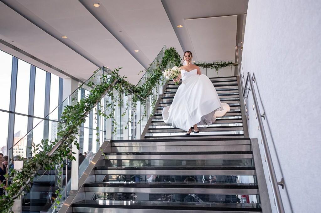 Bride walking down State Room glass staircase