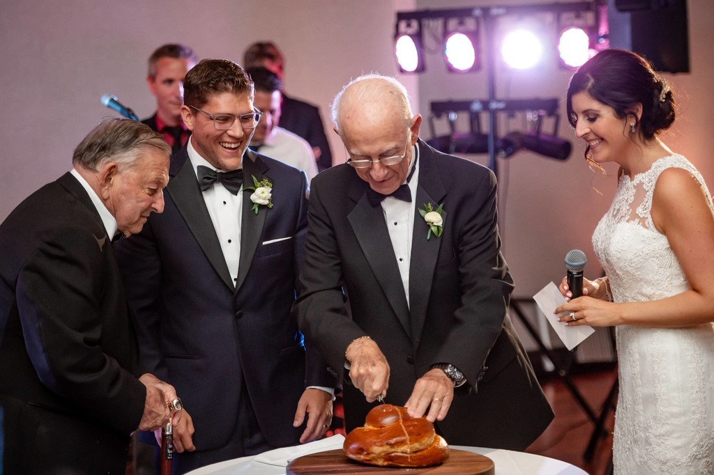 Grandfather slicing the challah at a Boston wedding