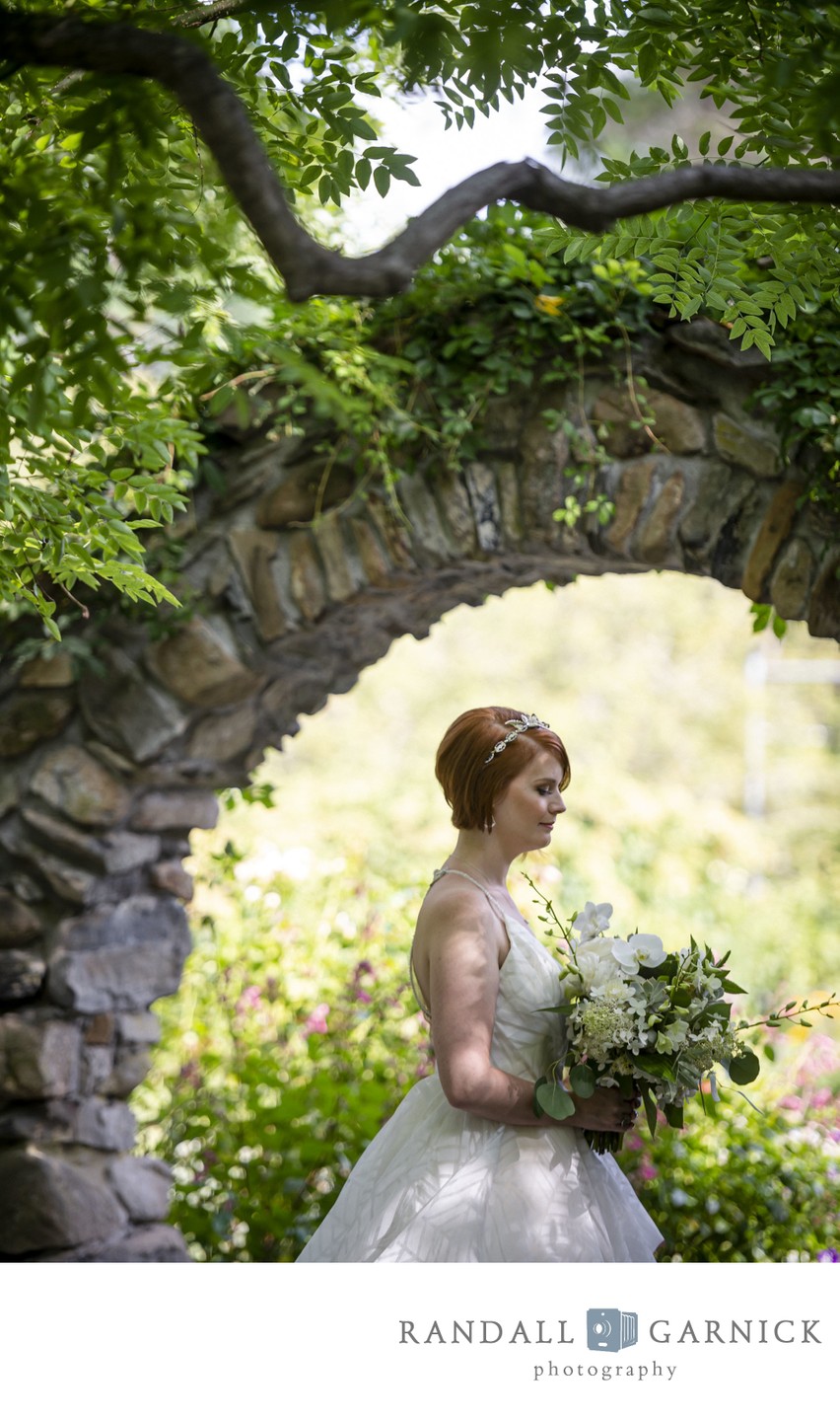 Bride under stone arch Blithewold Mansion wedding garden