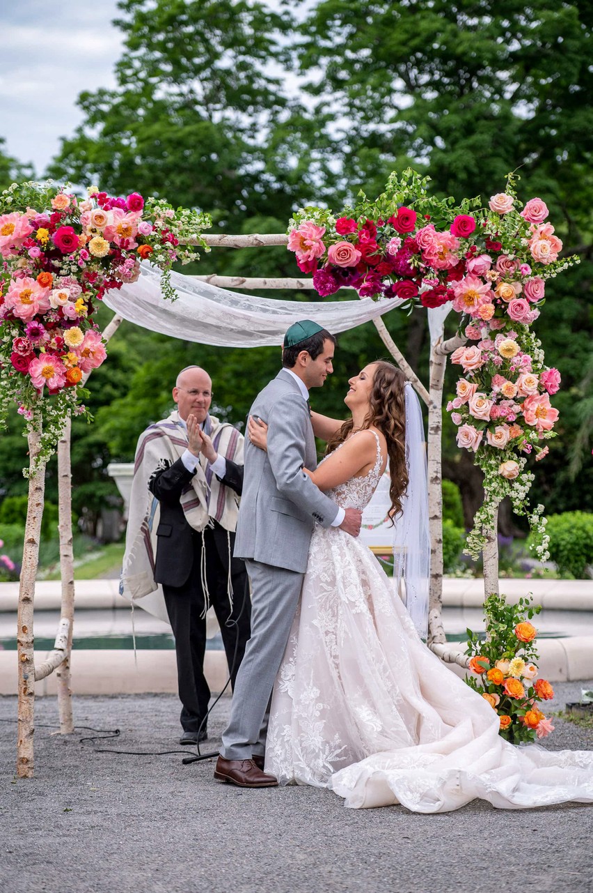 Wedding vows under floral arch at Elm Bank wedding ceremony