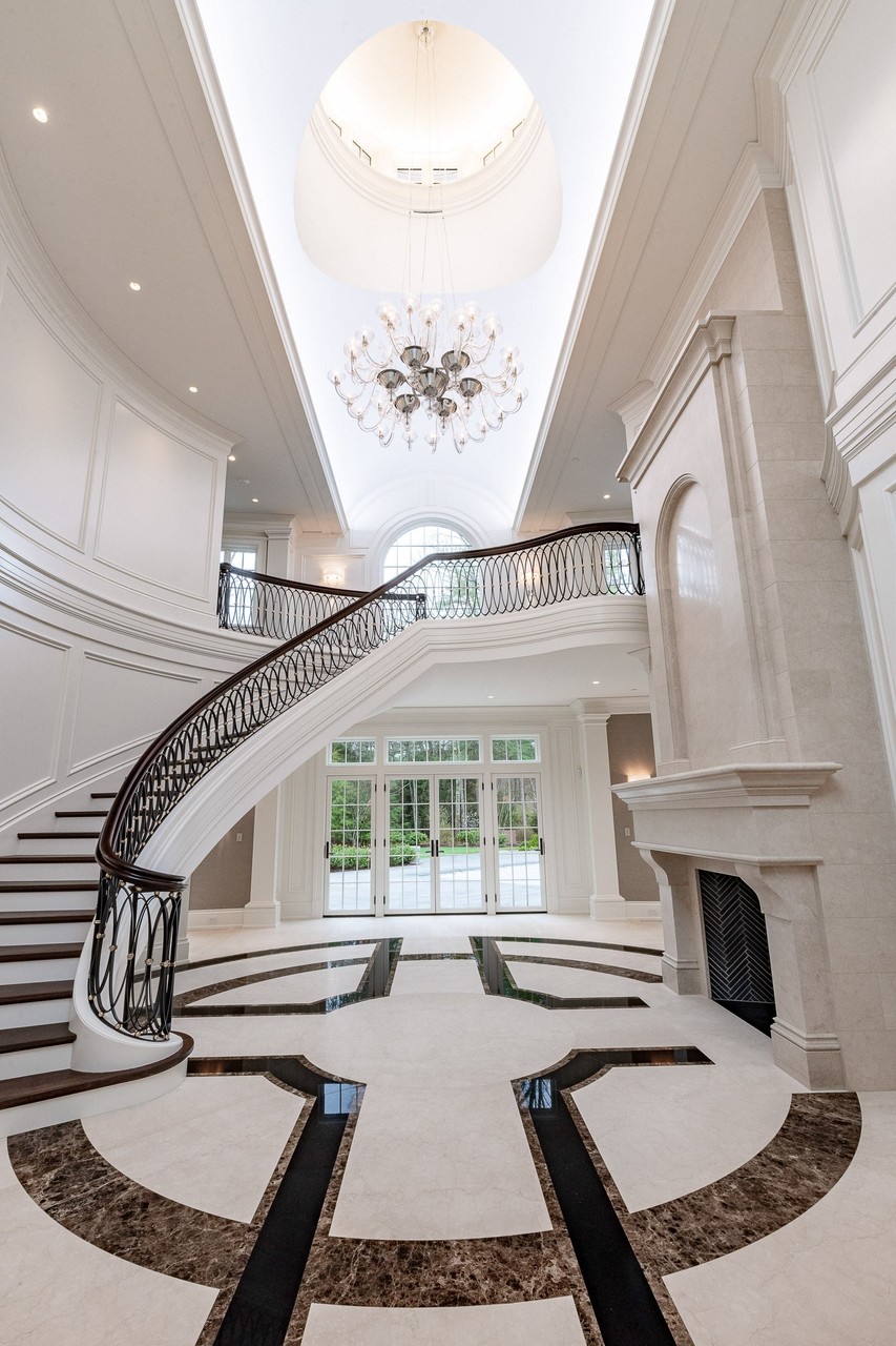 Grand foyer with curved staircase and arched window
