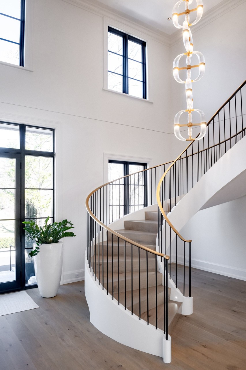 Grand spiral staircase with modern chandelier