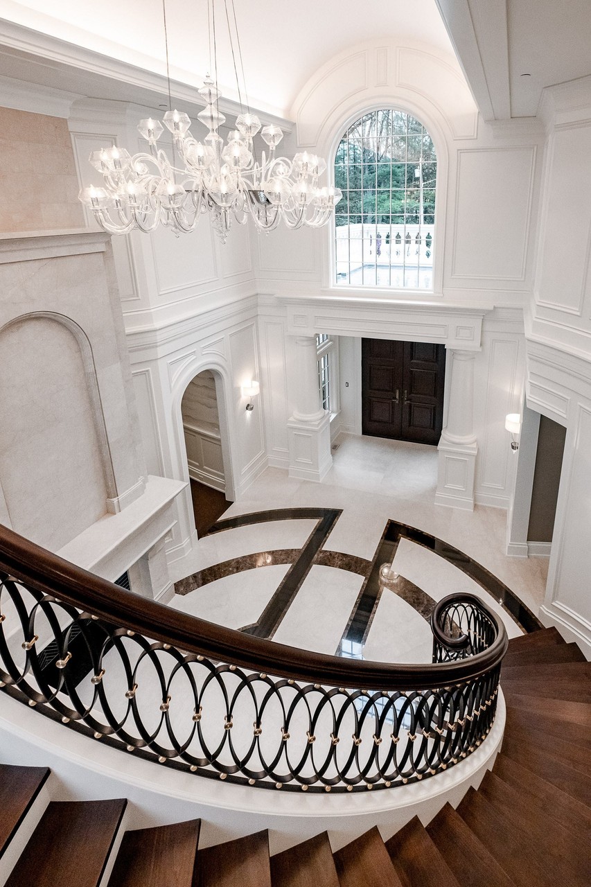 Grand entryway with two-story staircase and arched windows