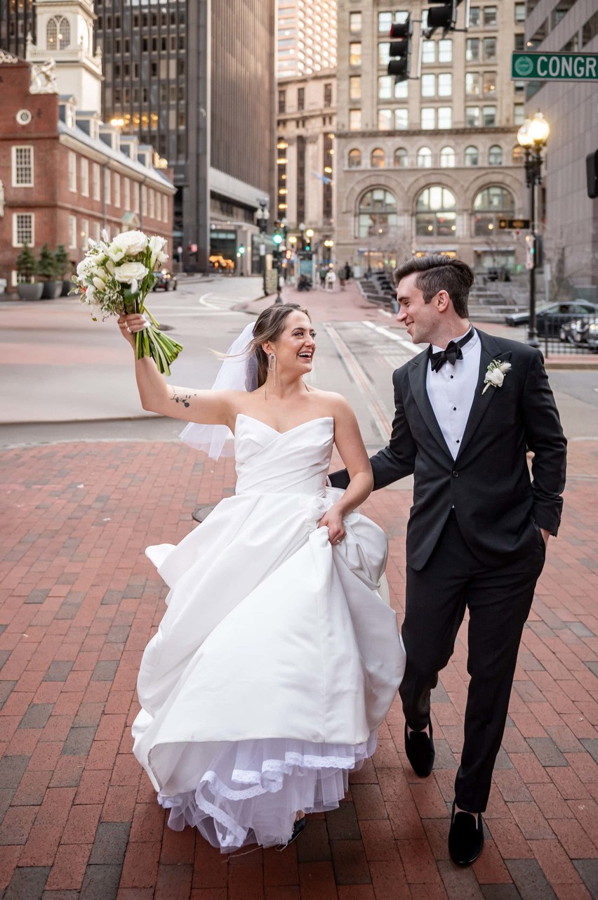 Couple walking in Boston with The Old State House in the background