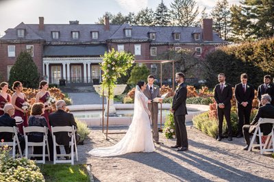 Wedding ceremony exchanging vows in the gardens at Elm Bank weddings