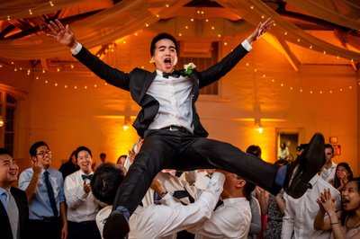 Groom in flight at his Gardens at Elm Bank wedding reception