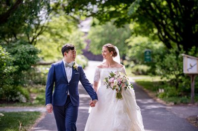 Newlyweds walking hand in hand at the Gardens at Elm Bank weddings