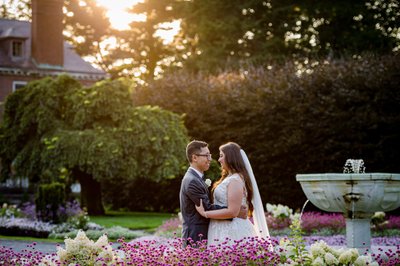 Newlyweds embrace by the fountain at Elm Bank weddings