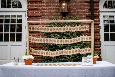 Escort card display with floral backdrop at Elm Bank wedding