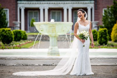 Laughing bride portrait by the fountain at Elm Bank weddings