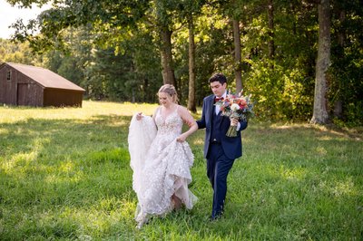 Just married stroll across the Fern Hill Barn fields