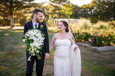 Bride and groom walking through gardens at Fern Hill Barn