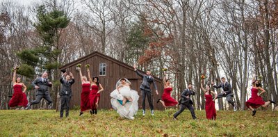 Wedding party in red outside Fern Hill Barn in winter