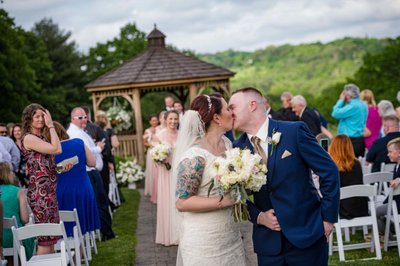 Ceremony recessional kiss at Fern Hill Barn