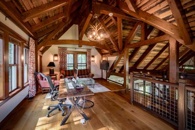 Rustic upstairs office with wood beams and antler chandelier 
