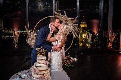 Cake cutting with nighttime city skyline view