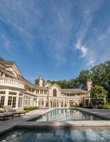 Luxury estate exterior with pool and classical stonework
