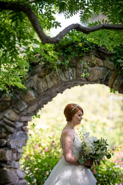 Bride under stone arch Blithewold Mansion wedding garden