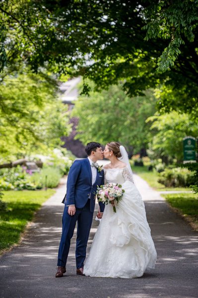 Bride and groom walking along a scenic Elm Bank wedding pathway