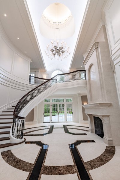 Grand foyer with curved staircase and arched window