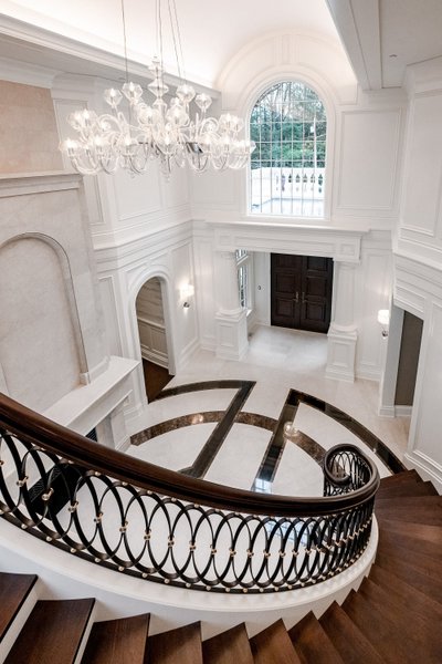 Grand entryway with two-story staircase and arched windows