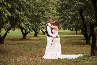 Bride and Groom Kissing in Peach Orchard