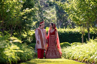 Indian Bride and Husband walking down a grassy aisle