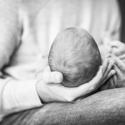 Father cradling newborn. Photography by Missy Timko.