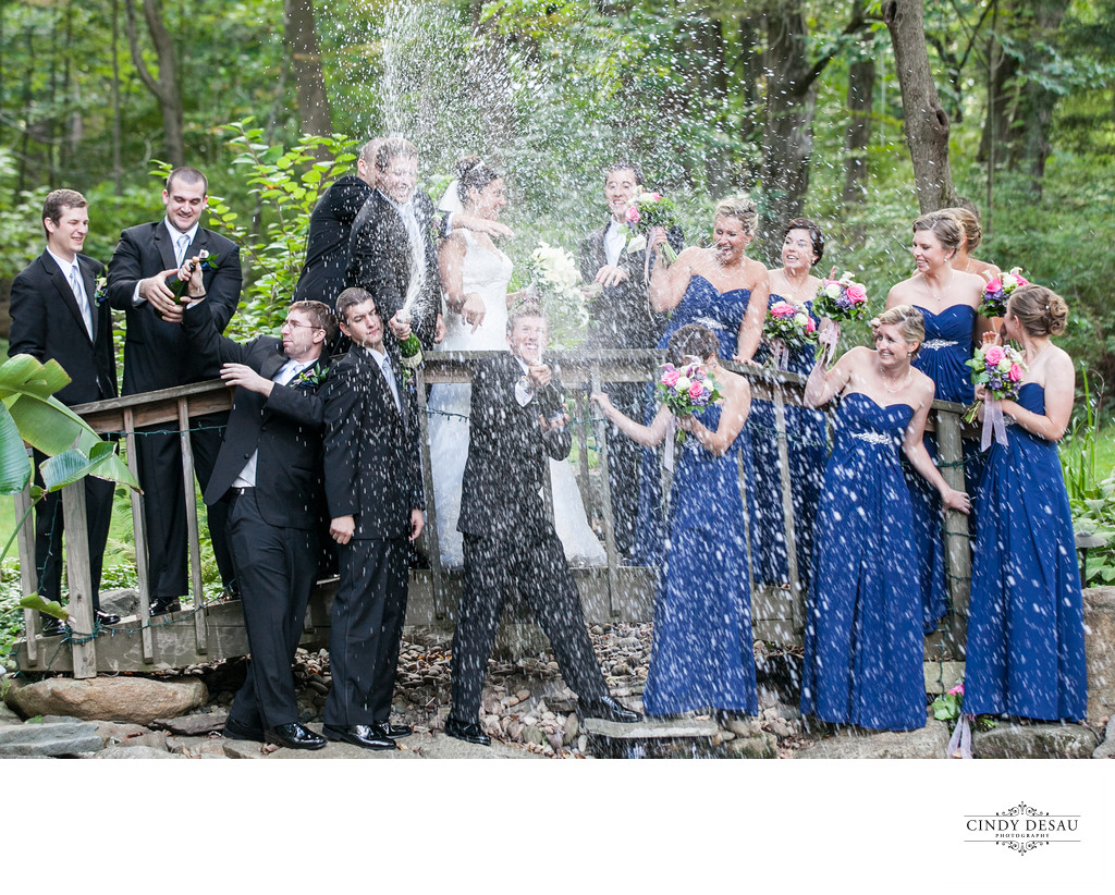 Surprised Wedding Party Pops Champagne Photograph