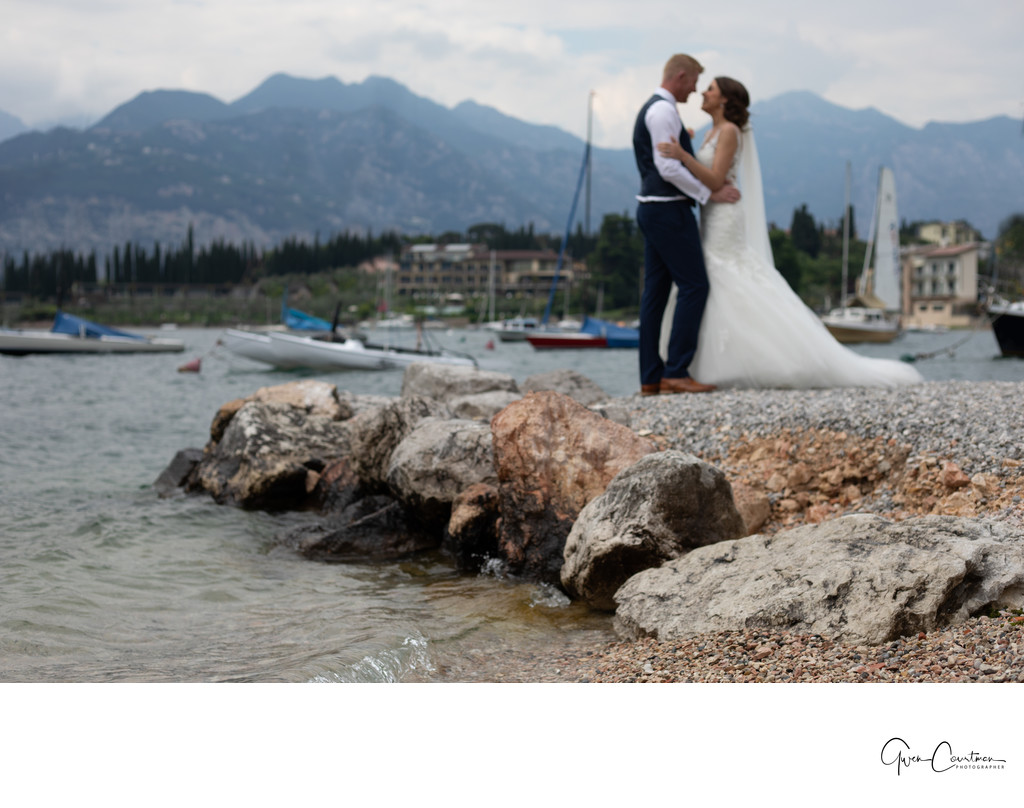 Bride and groom in love on the rocks in Malcesine