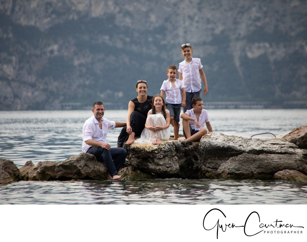 Family sitting on the rocks, trash the dress Lake Garda