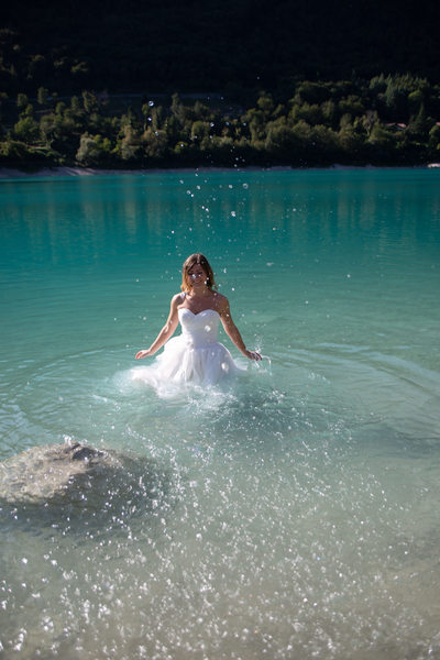 Bride splashing in Lake Tenno, Italy