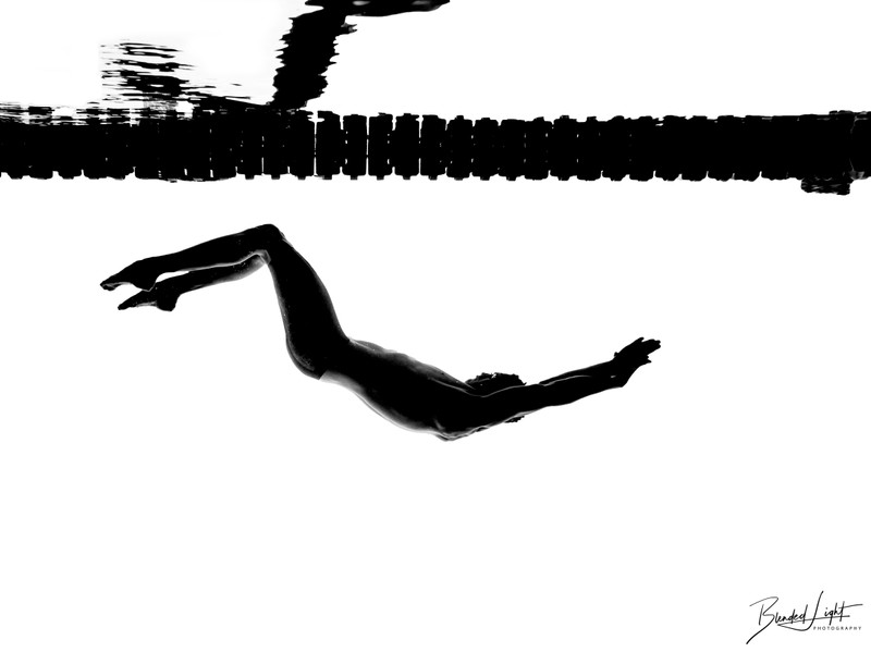 Backstroke silhouette underwater against lane lines