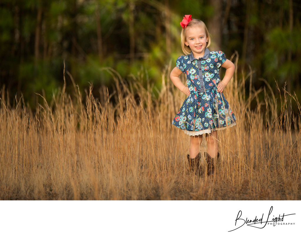 Little girl smiling among the fall grasses portrait
