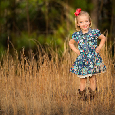 Little girl smiling among the fall grasses portrait