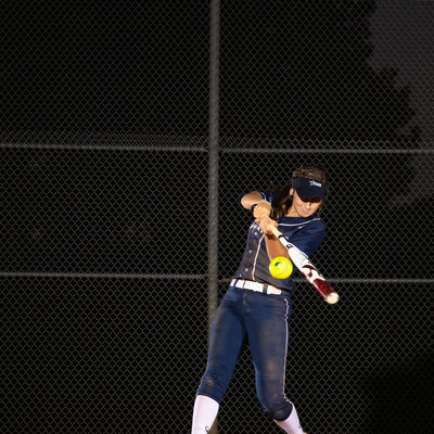 Softball player swinging at softball image