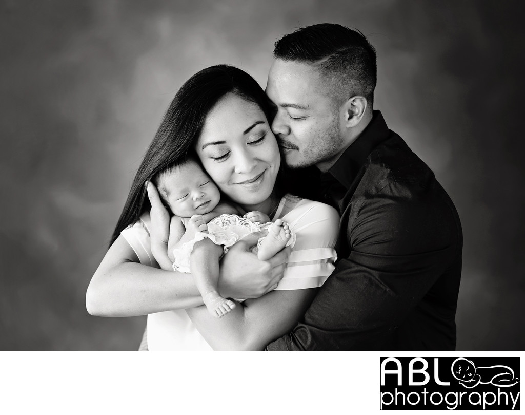 San Diego family photographer with family hugging newborn