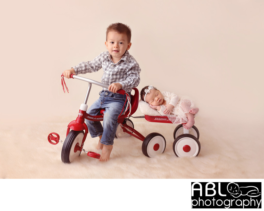 Older brother riding a bike with baby sister, newborn photos