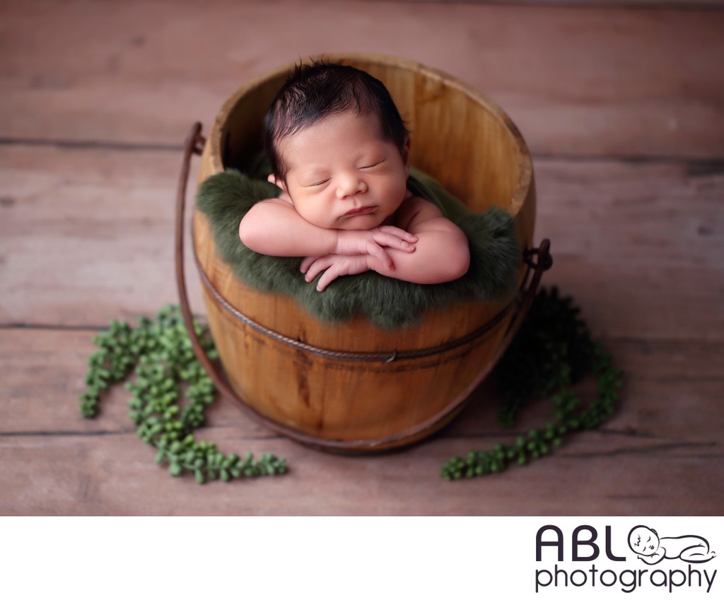 Baby in bucket with greenery