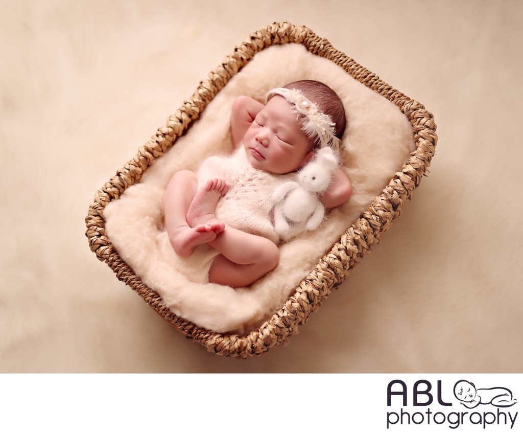 Newborn photography San Diego baby in a basket with toy