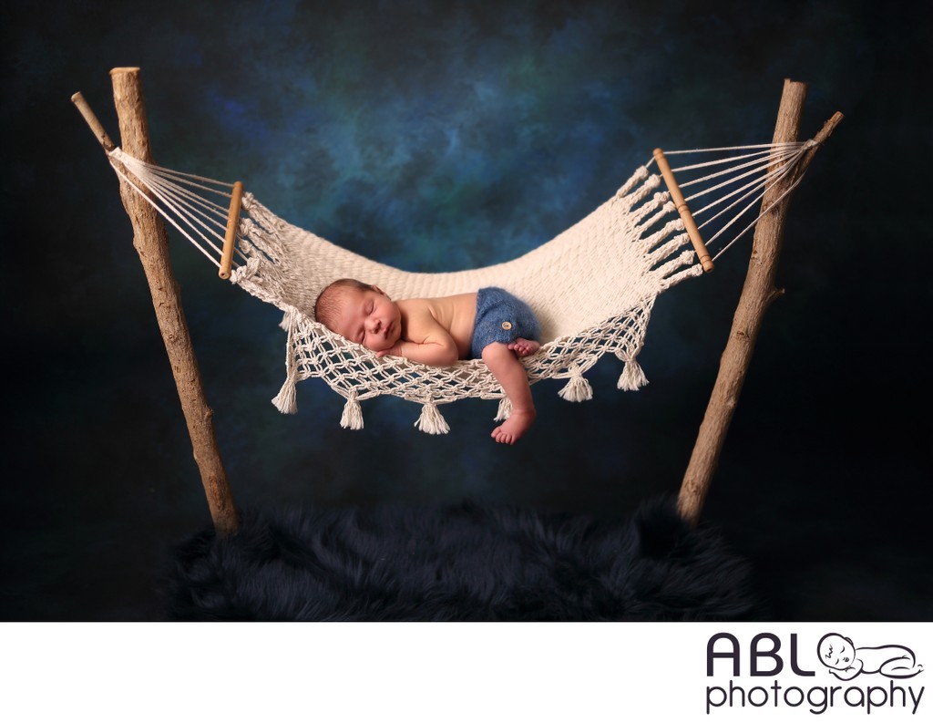 newborn baby in blue hammock