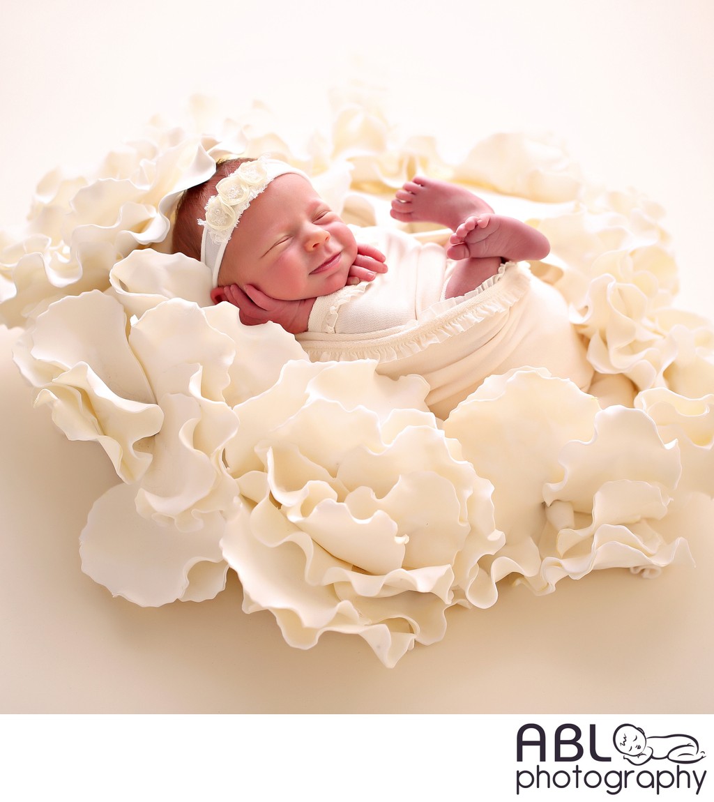 baby in cream flower, newborn photos in San Diego