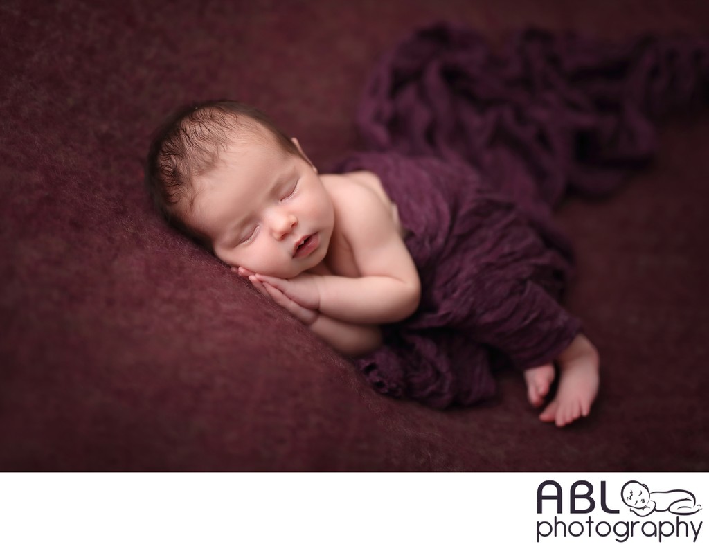 baby posed on purple blanket