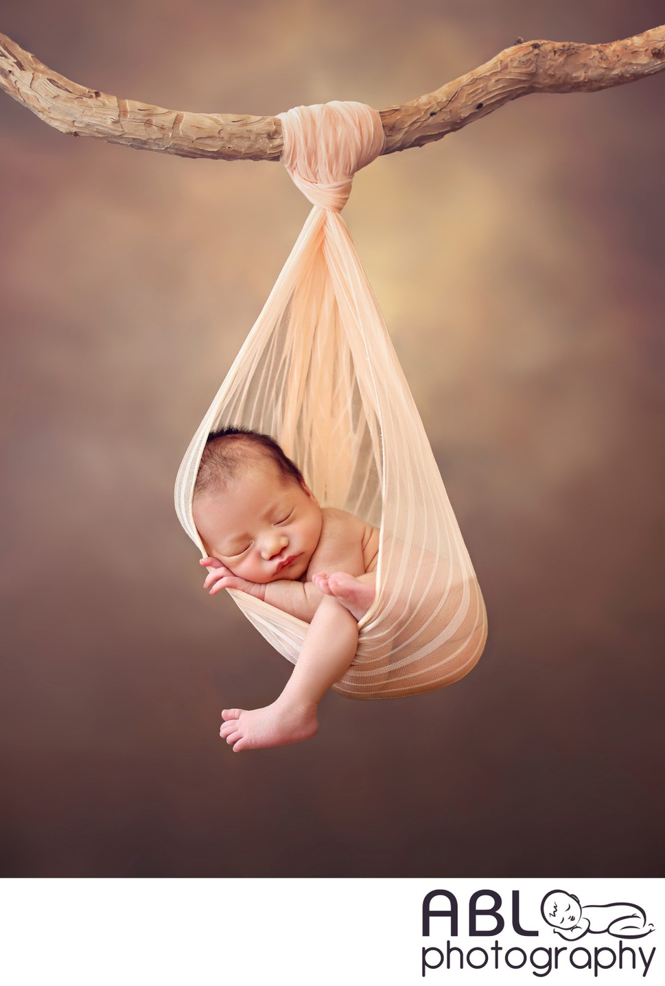 Newborn Photography San Diego. Baby hanging off a tree branch