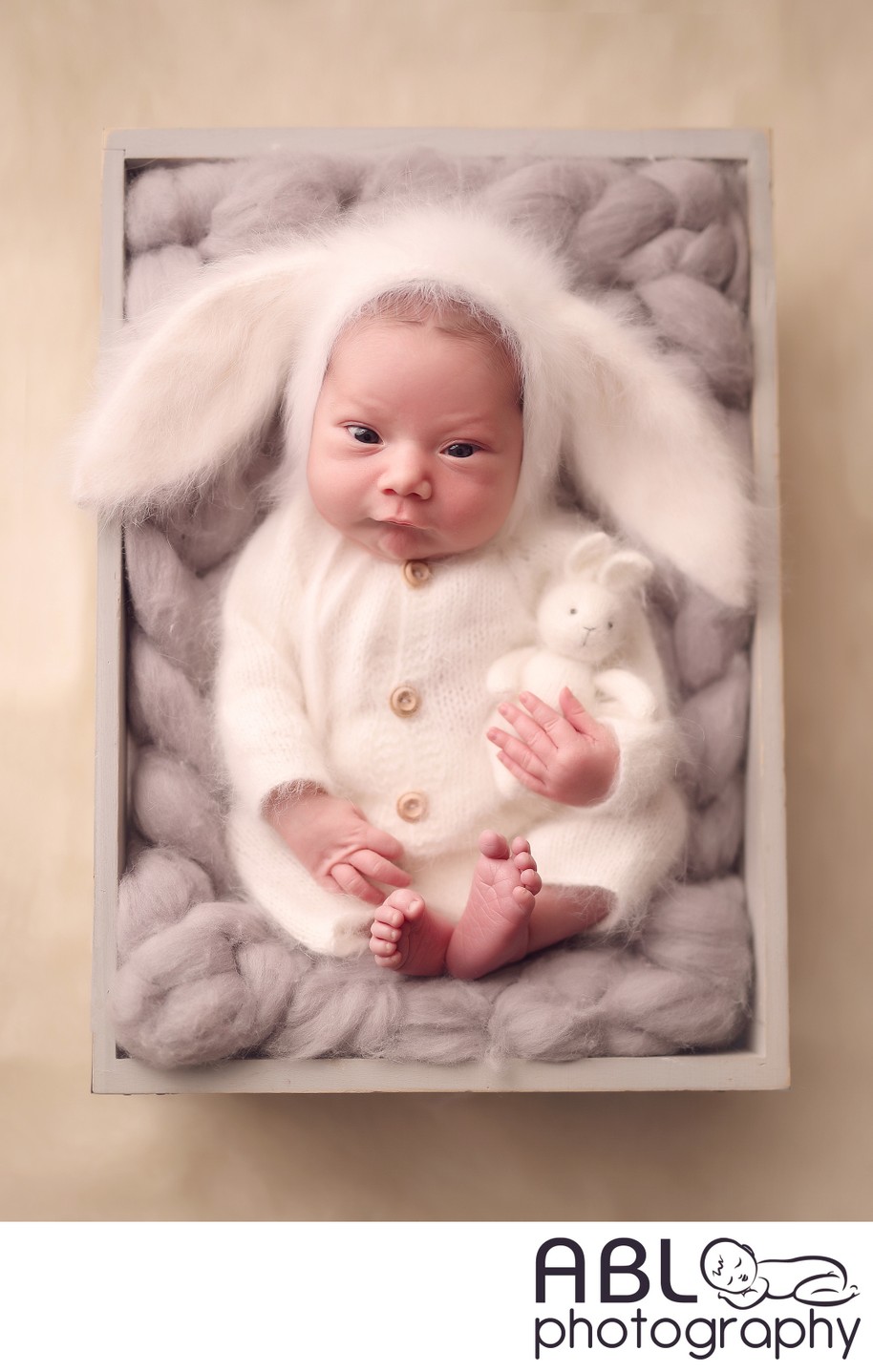Funny newborn baby in fluffy bunny outfit