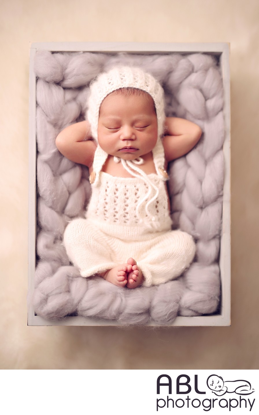 Newborn boy in gray box