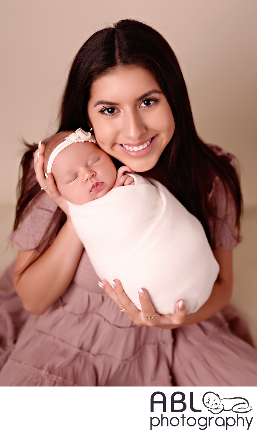 Big sister holding newborn