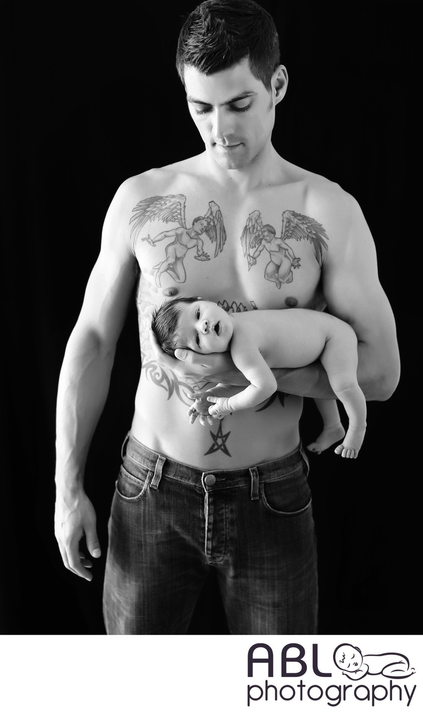 Father with tattoo holding baby