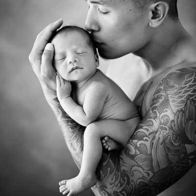 Father kissing newborn son