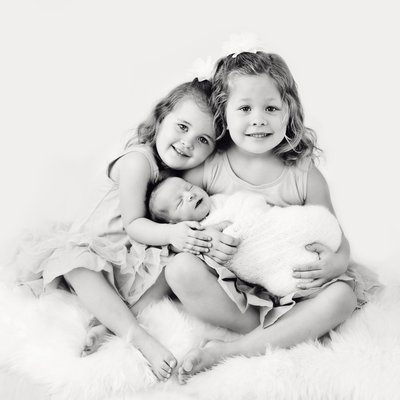 San Diego newborn photographer big sisters holding newborn